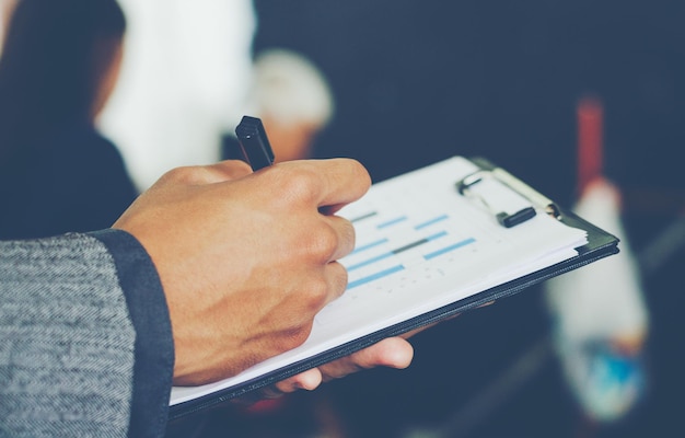 Cropped hands of businessman with pen and chart in office