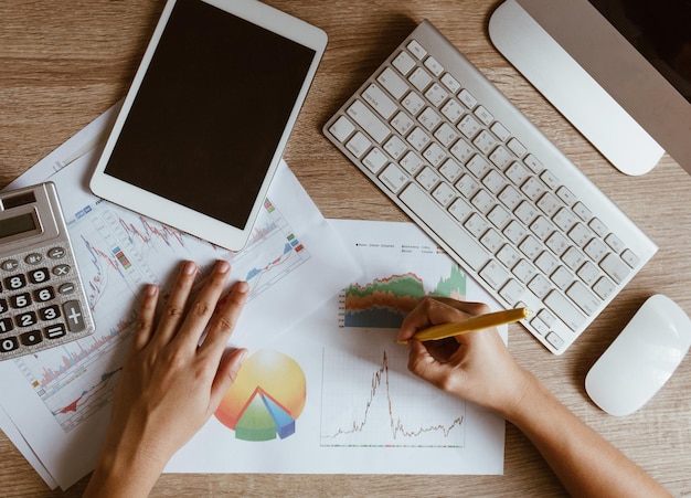 Cropped hands of businesswoman writing on document at table in office