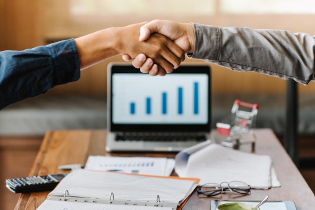 Cropped hands of businesswomen shaking hands in office