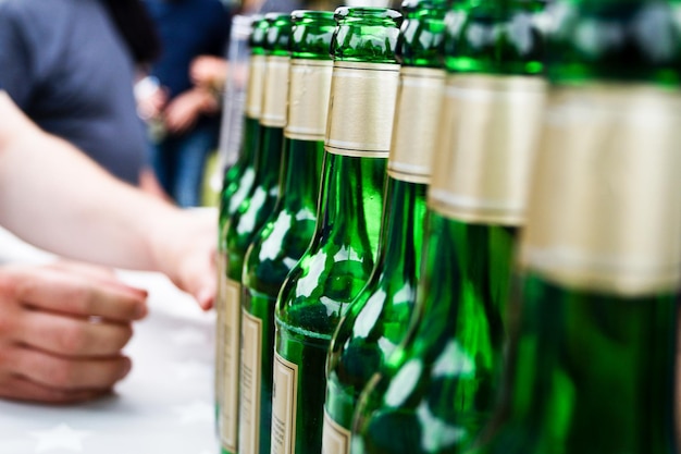 Photo cropped hands by beer bottles at table