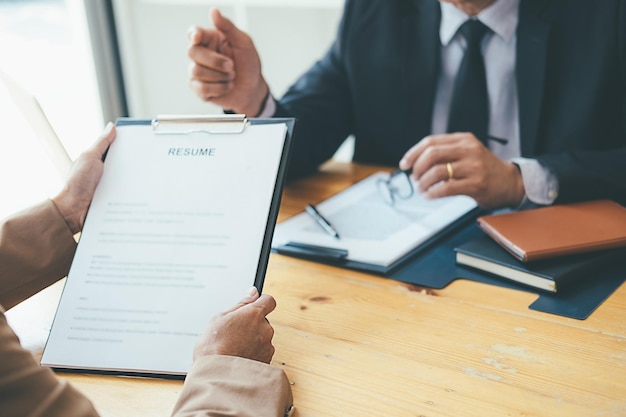 Cropped hands of candidate giving resume to manager in office