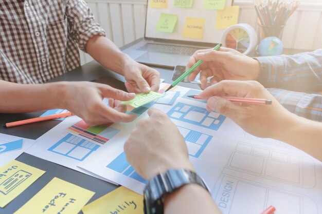 Photo cropped hands of colleagues pointing on paper in office