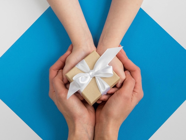 Cropped hands of couple holding gift box