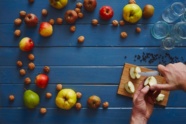 Фото Руки, разрезающие яблоко за столом.