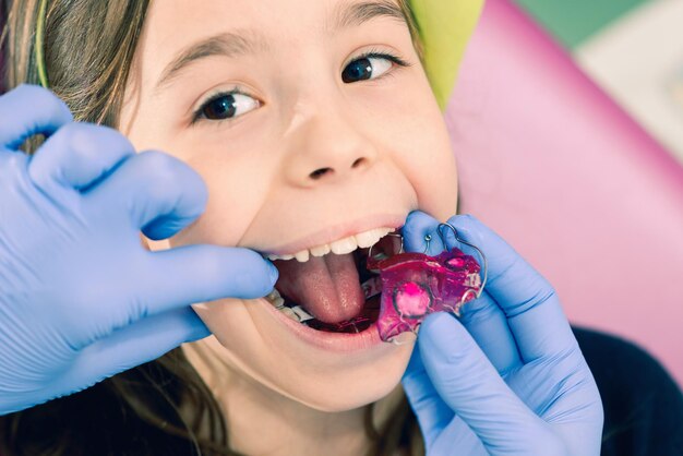 소녀 의 치아 를 검사 하는 치과의사 의 잘라진 손