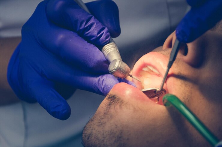 Photo cropped hands of dentist giving treatment to man