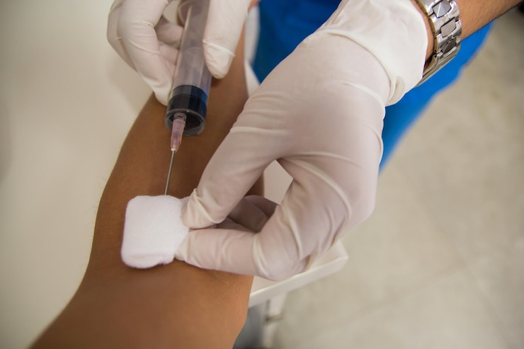 Photo cropped hands of doctor injecting patient at hospital