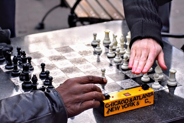 Cropped hands of friends playing chess