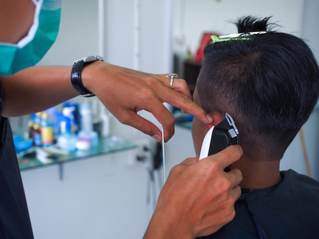 男性のをカットするヘアドレッサーの手をカットした
