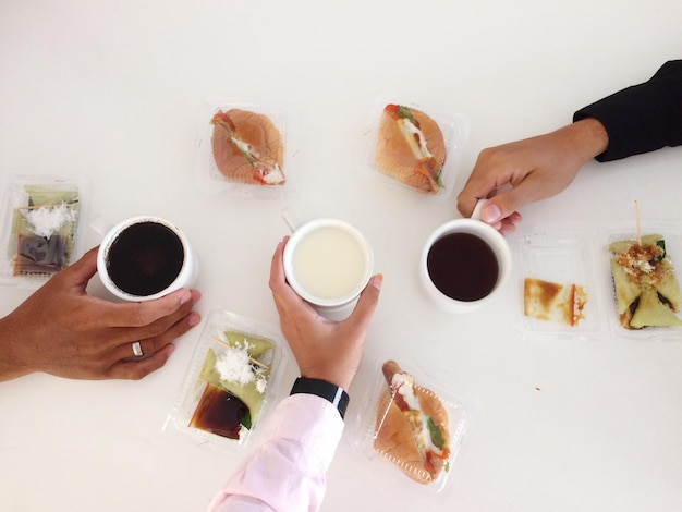 Photo cropped hands having tea and breakfast