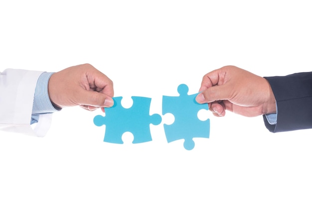 Cropped hands holding blue puzzles over white background