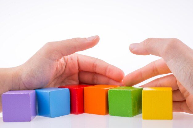 Photo cropped hands holding colorful toy blocks on white background
