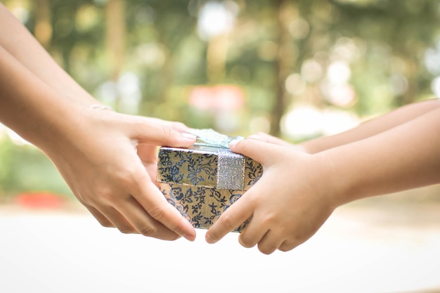 Photo cropped hands holding gift box