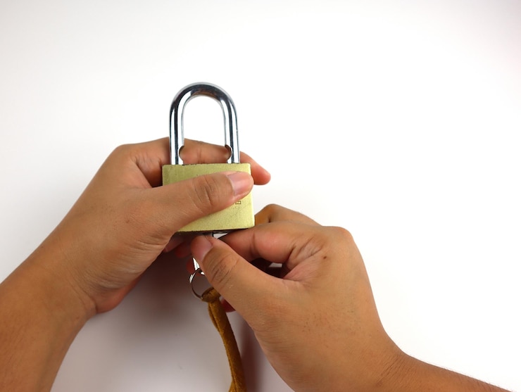 फोटो cropped hands holding lock and key over white background