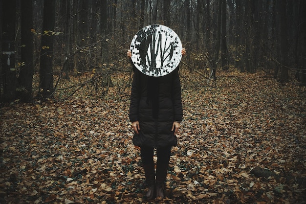 Photo cropped hands holding mirror in front of woman in forest