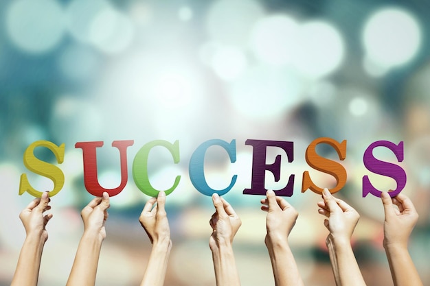 cropped hands holding success text
