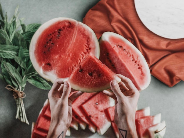 Photo cropped hands holding watermelon slice