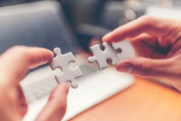 Photo cropped hands of jigsaw pieces in office