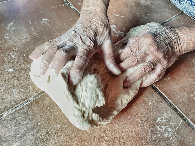 Foto mani tagliate che impastano la pasta