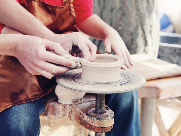 Photo cropped hands making clay product at pottery