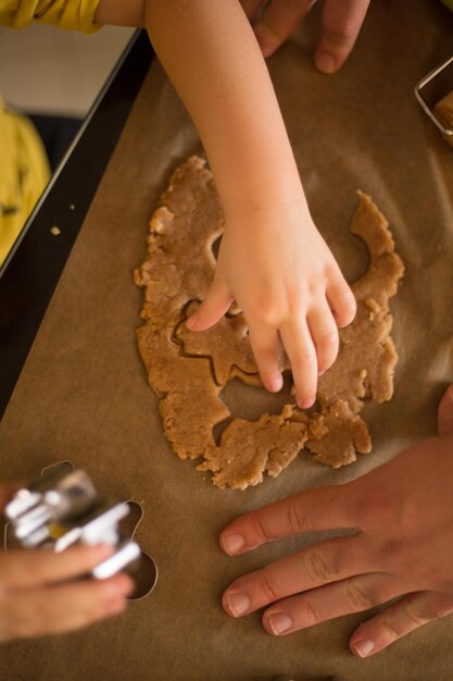 Photo cropped hands making gingerbread cookies