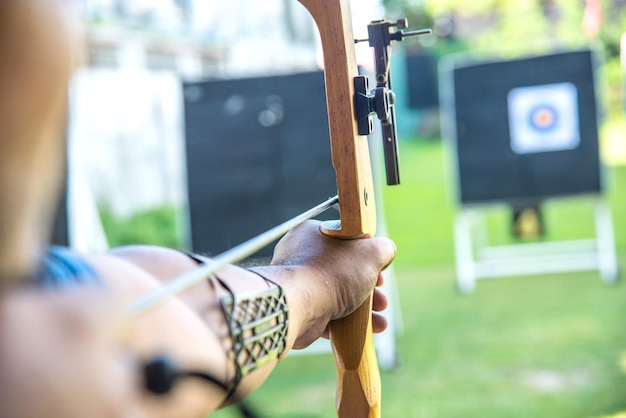 Photo cropped hands of man aiming archery