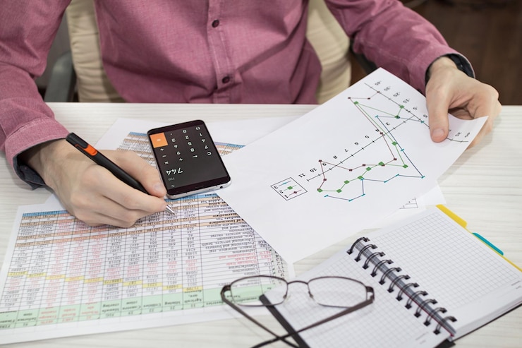 Photo cropped hands of man doing calculation at table