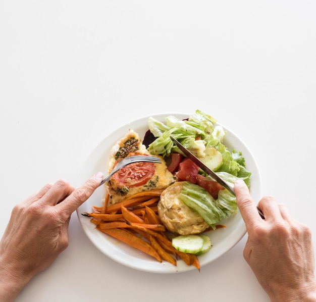 Cropped hands of man having food on white table