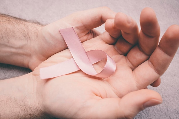 Cropped hands of man holding breast cancer awareness ribbon