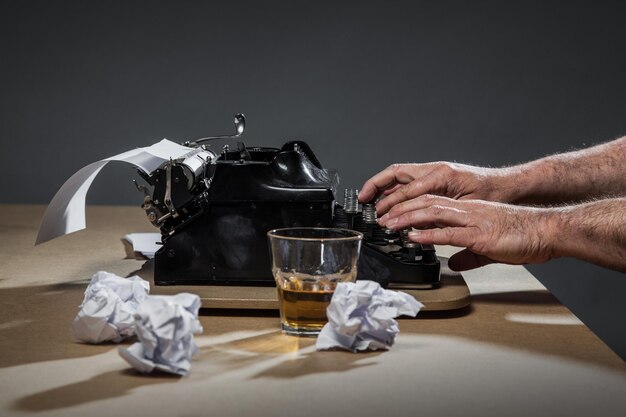 Foto mani tagliate di uomo che scrive sulla macchina da scrivere al tavolo