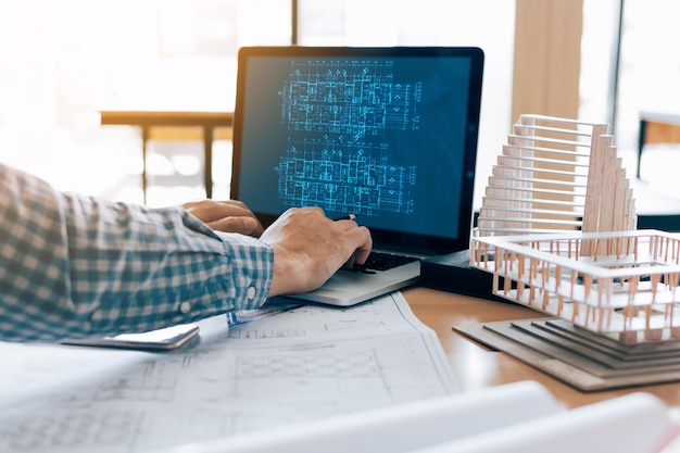 Cropped hands of man using laptop on table