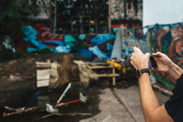 Photo cropped hands of man using mobile phone while standing on street