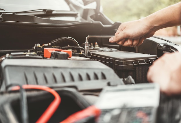 Cropped hands of mechanic repairing car engine