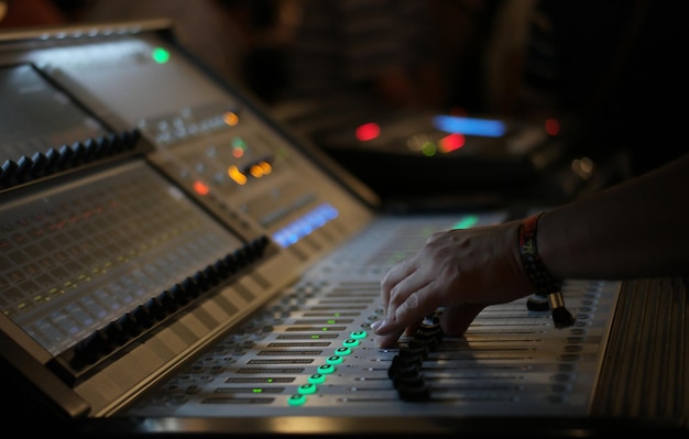 Photo cropped hands mixing music with sound recording equipment in studio