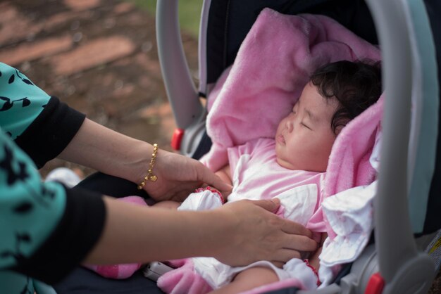 Foto mani tagliate di una madre che tiene la figlia nel passeggino