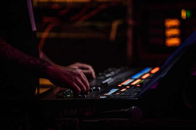 cropped hands of musician adjusting sound mixer in nightclub