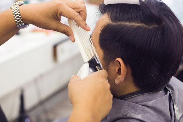 사진 미용실 에서 고객 의 머리카락 을 잘라주는 이발사 의 잘라진 손