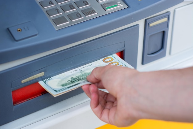 Фото Обрезанные руки человека, вынимающего наличные из банкомата