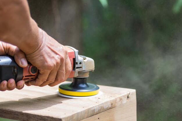 写真 木に作業道具を使用している人の手を切り取った