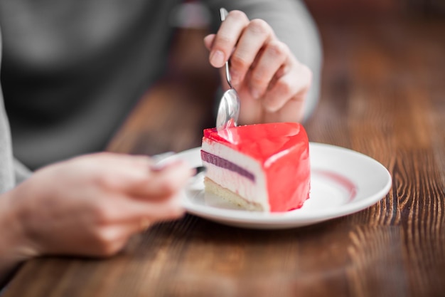 写真 テーブルでケーキを食べている女性の切断された手