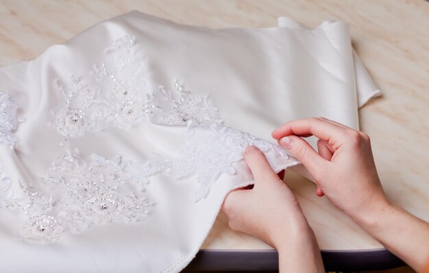 写真 結婚式のドレスを縫う女性の切断された手