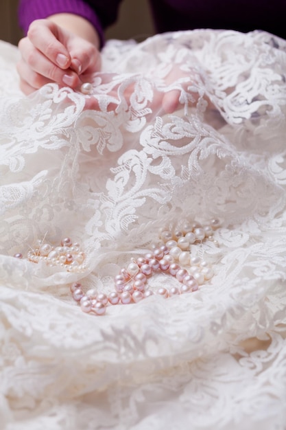 写真 結婚式のドレスを縫う女性の切断された手