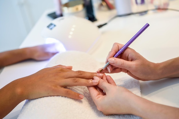 cropped hands painting customer fingernails