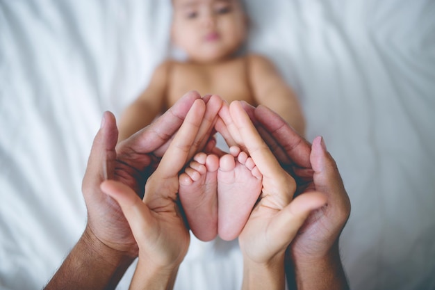 Отрезанные руки родителей, держащих ноги младенца.