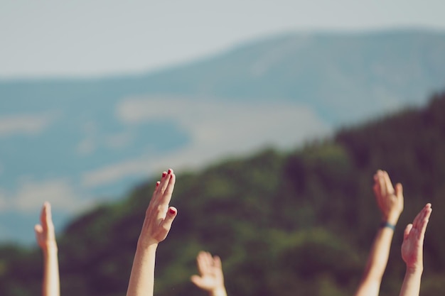 Cropped hands of people against mountain