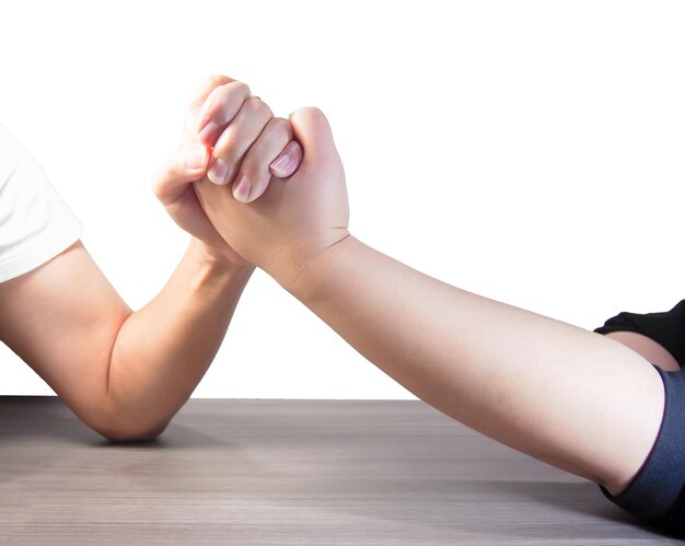 Photo cropped hands of people arm wrestling on table against white background