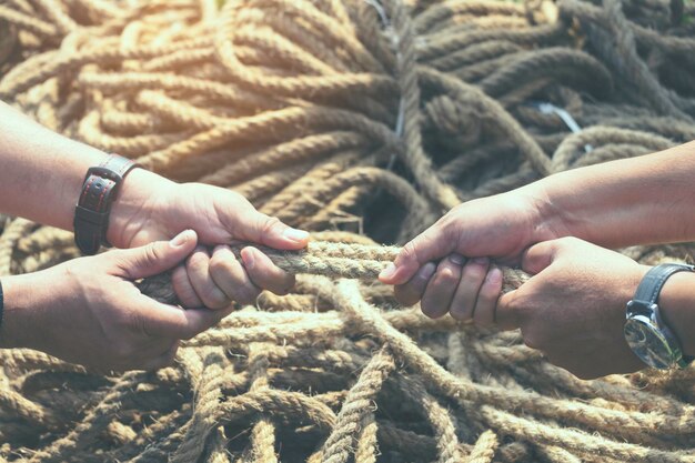 Foto mani tagliate di persone che tirano la corda