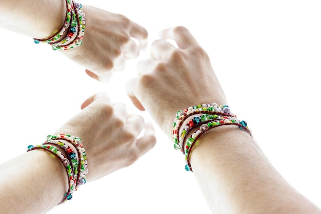 Photo cropped hands of people with bracelets against white background