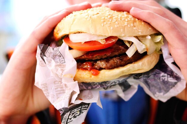 Cropped hands of person having burger