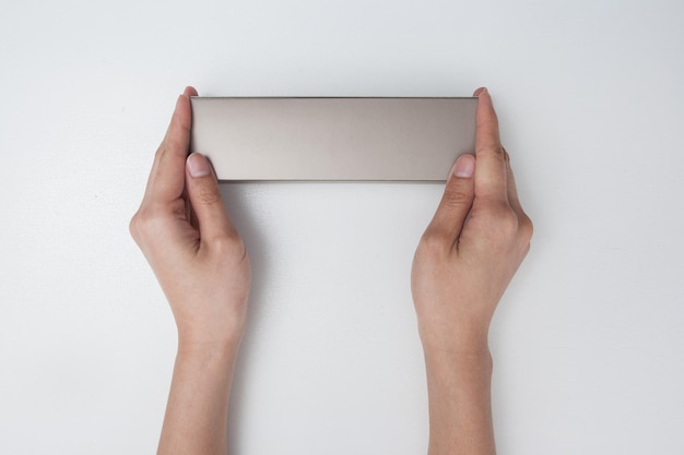 cropped hands of person holding cardboard box over white background